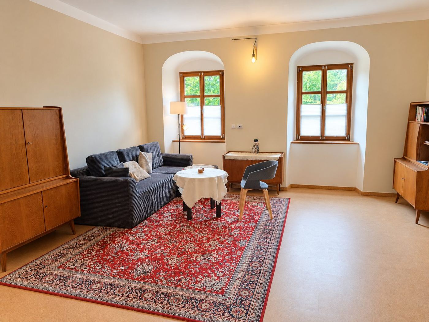 Wohnzimmer der Ferienwohnung mit Sofa, Perserteppich und antiken Möbeln